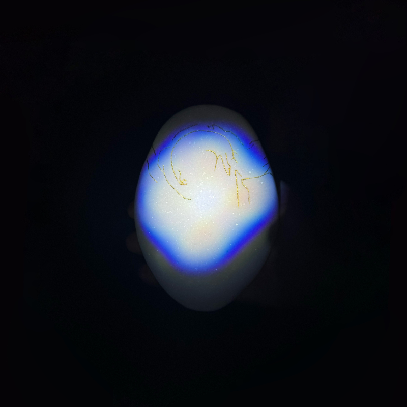 Glass orb with blue and yellow coloration on a black background