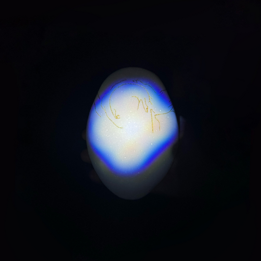 Glass orb with blue and yellow coloration on a black background