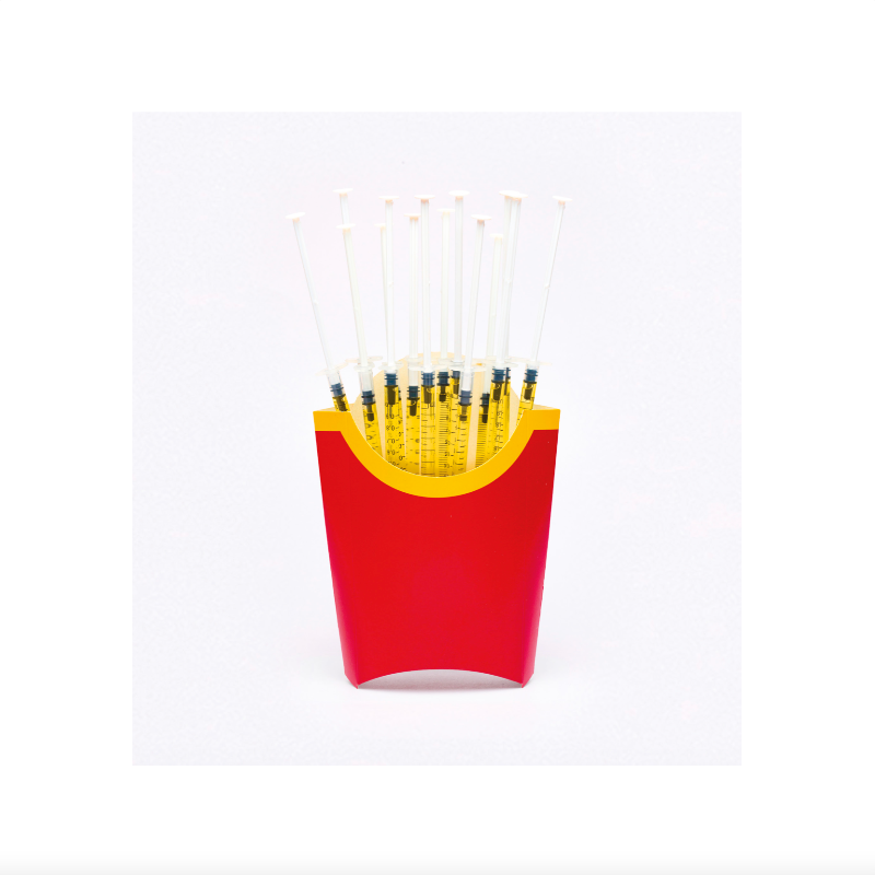 Red and yellow container with black objects resembling french fries on a white background