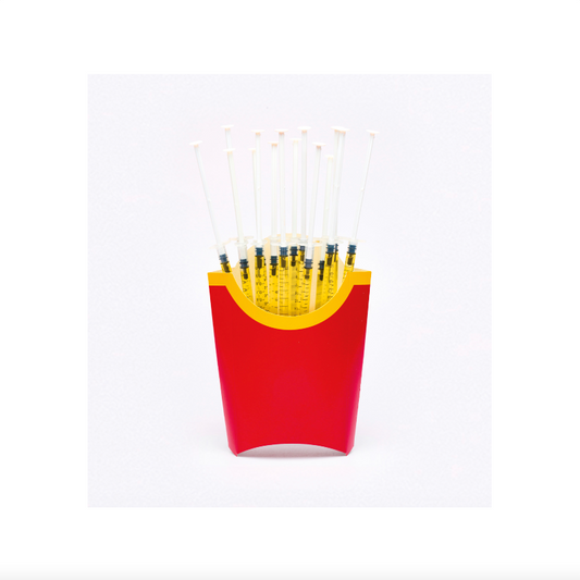 Red and yellow container with black objects resembling french fries on a white background
