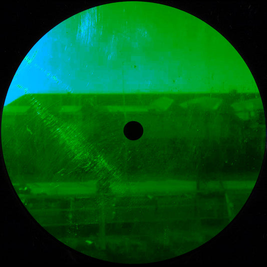 Green-tinted viewfinder or scope with a black dot in the center, on a dark background.