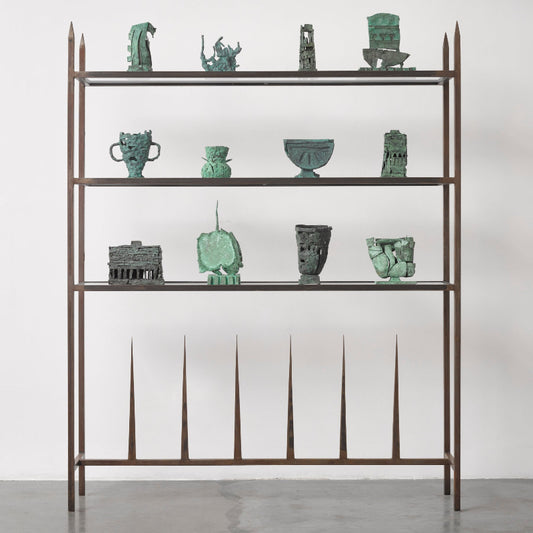 Metal shelving unit with green ceramic pieces on a white background